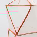 Close-up of orange mesh chairs sturdy frame and webbing detailing.