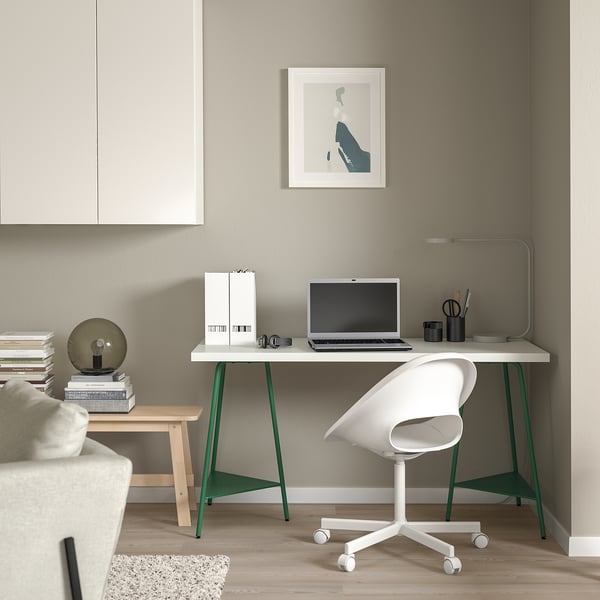 Minimalist home office: white TILLSLAG desk, green legs, compact. White chair, laptop, simple decor.