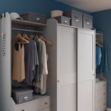 Closets with clothes, TJOG boxes, blue walls.