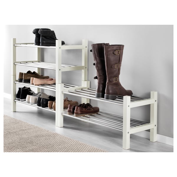 White wooden shoe rack holds multiple pairs, stacks for extra storage.