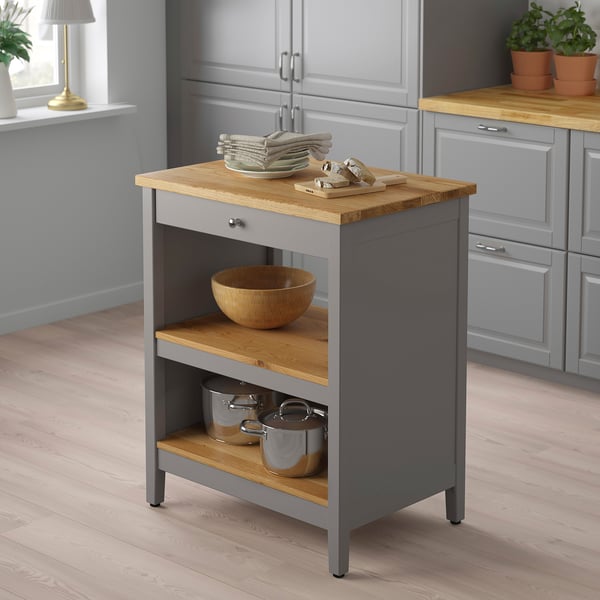 Small grey kitchen island, TORNVIKEN, wood top, fits neatly in corner, holds plates, bowls, and pots.