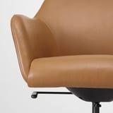 A close-up of a tan leather office chairs padded armrest and seat, showcasing its comfortable and stylish design.
