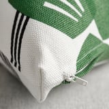 Close-up of zipper detail on high-quality green and white cushion cover, showcasing intricate stitching and fabric texture.