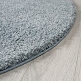Round grey area rug on light wooden floor. Soft, durable, and non-shedding texture visible.