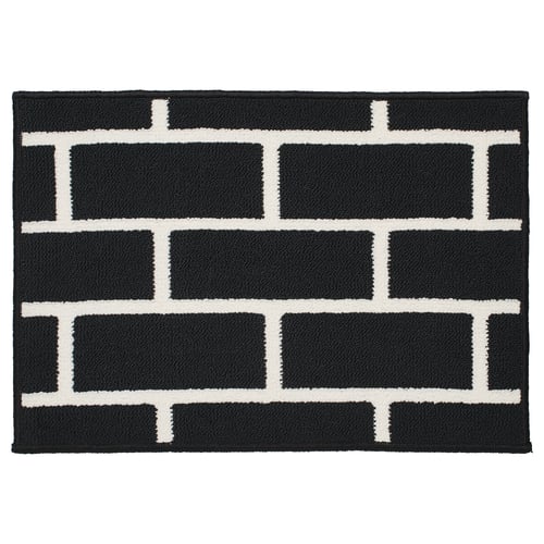 Black and white rectangular chequered rug. Modern, geometric design. Soft, non-slip material.