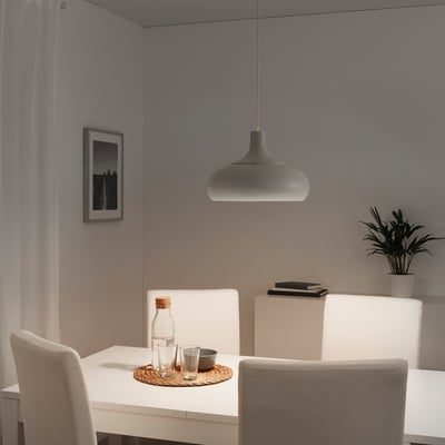 Modern dining area with grey VÄXJÖ pendant lamp, white chairs, and a clean, minimalist design.