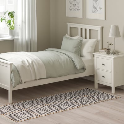 Cozy bedroom with white VAMDRUP rug. Rug is neutral tones, wool & cotton, rectangular, traditional scandinavian weave. Fits by bed, warm & durable.