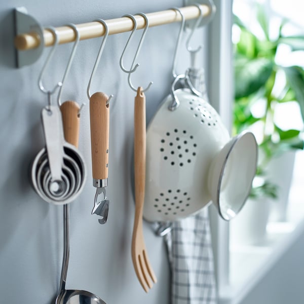 Kitchen tools on hooks: colander, opener, spoons, spatula.