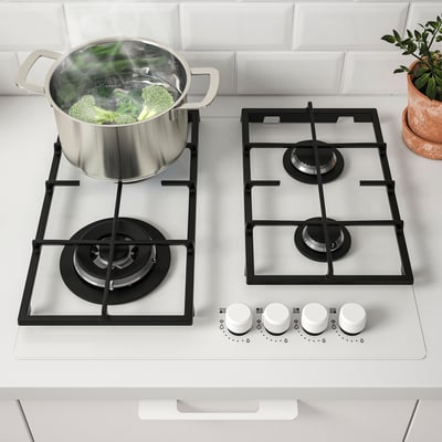Gas stove with boiling broccoli, controls in front.