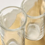 Clear glass vases, handcrafted with precision, sitting on beige cloth, showcasing quality and elegance.