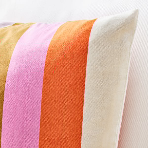 Decorative cushion with vibrant horizontal stripes in pink, orange, gold, and white, soft iridescent fabric.