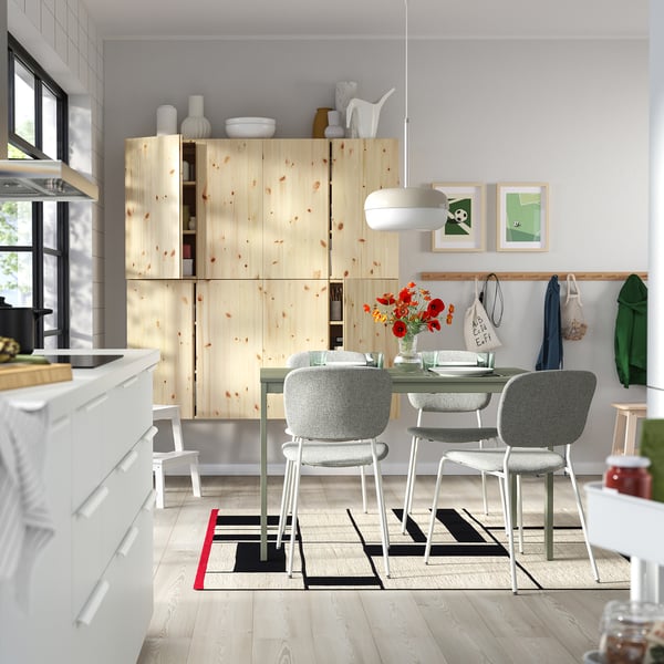 Modern kitchen VIHALS dining set. Light wood cabinet, white chairs surround glass table. Bright, minimalist design.