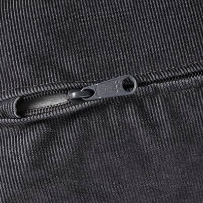 Closeup of zip on modern, textured black fabric, likely part of a high-quality sofa or upholstered item.