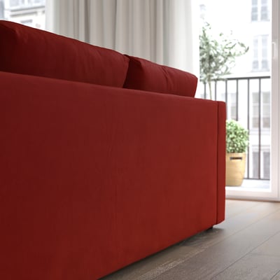 Red modular sofa, soft high resilience cushions, large window beside, potted plant on balcony, modern interior.