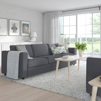 Modern living room with large gray VIMLE sofa, light wood coffee table, and large windows with white curtains.