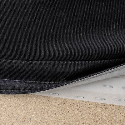 Black sofa fabric with white backing, displayed on cork surface.