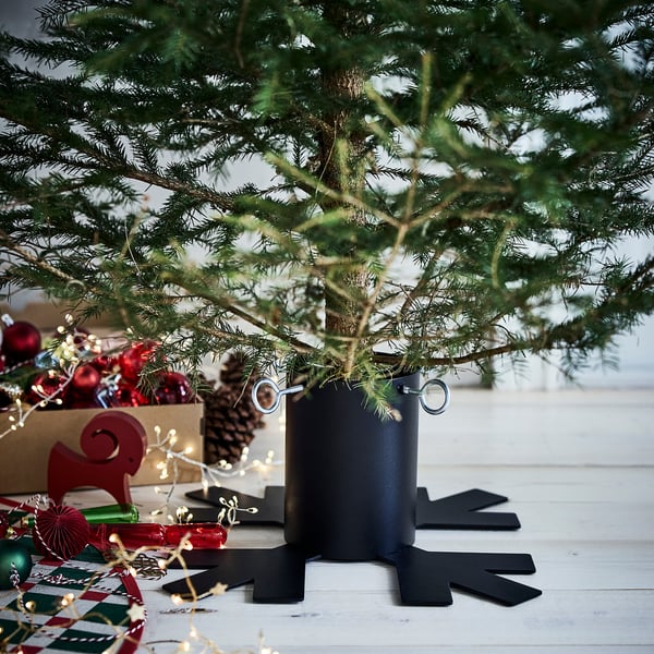 Small black VINTERFINT tree stand supports christmas tree, fits tightly with adjustable screws for stability.