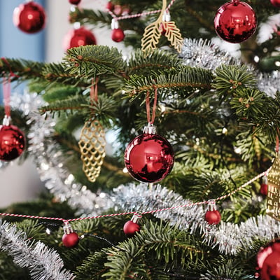 Christmas tree with red & gold ornaments, bright tinsel, and lights.