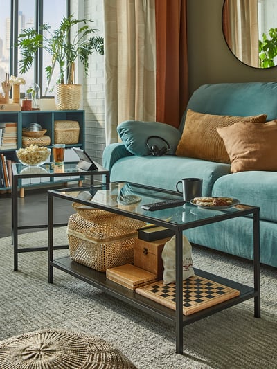 Cozy living room with teal sofa, wooden coffee table, and woven baskets.