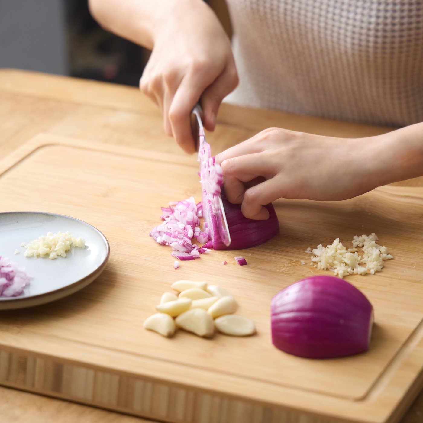 도마에서 칼로 양파를 써는 손