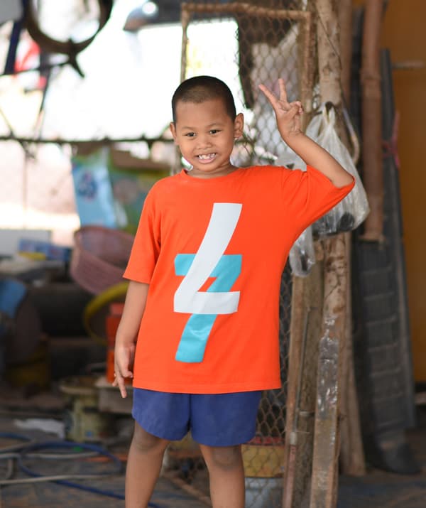 ภาพบุคคลของเด็กชายกำลังทำสัญลักษณ์สันติภาพด้วยนิ้วของเขา