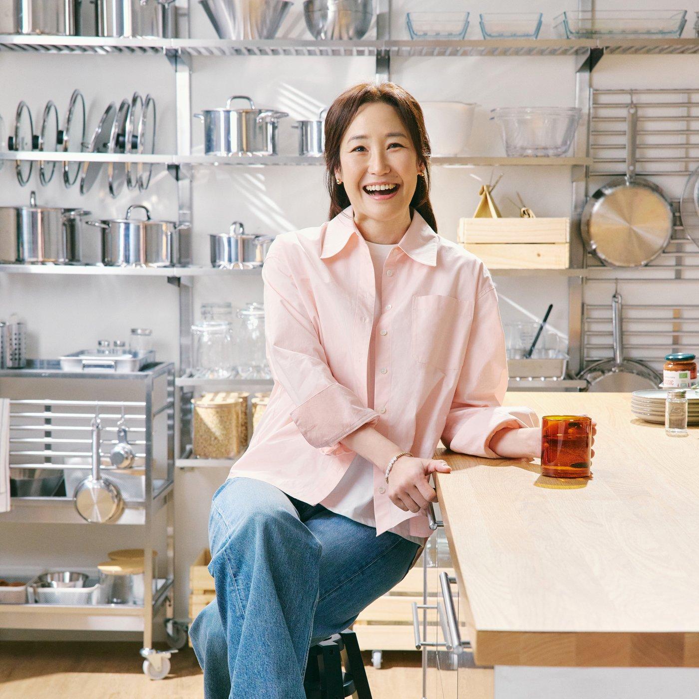 이케아 강주은 엠베서더가 주방에 앉아서 활짝 웃고 있는 사진.