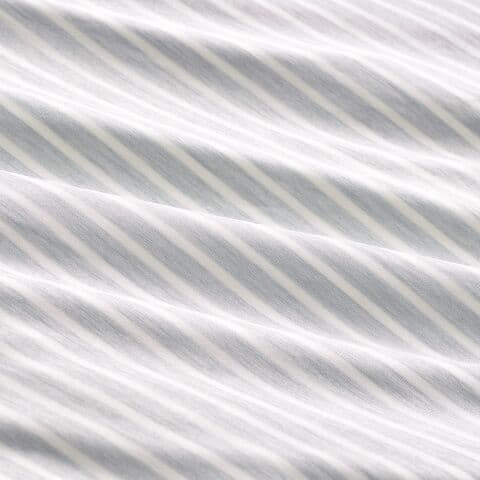 회색 바탕에 스트라이프 무늬가 있는 침구가 줌인된 이미지