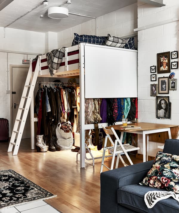 เตียงสูงที่มุมของห้องและตู้เสื้อผ้าแบบวอล์กอินอยู่ข้างใต้