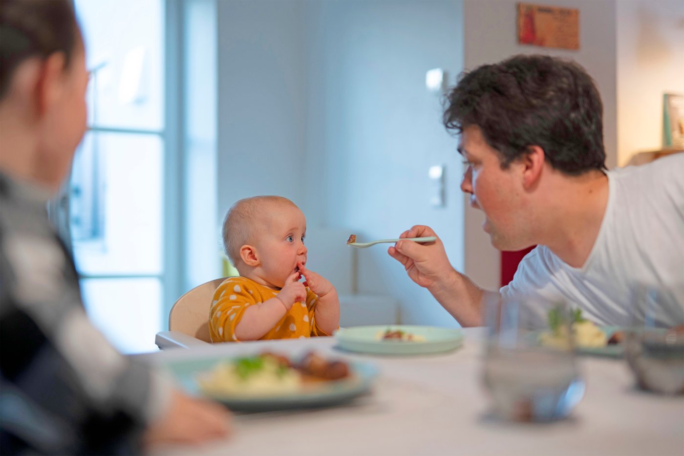 한 남성과 한 여성이 마른 낙엽으로 덮인 숲 속에서 피크닉 담요 위에 앉아 있는 모습.
