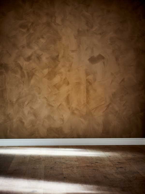 ส่วนของห้องเปล่าที่มีพื้นไม้และผนังสีโทนน้ำตาลเข้มและพื้นผิวแบบหนังด้าน