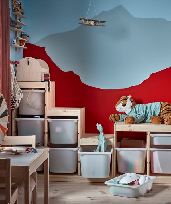 มุมห้องนอนเด็กที่มีชั้นวางของเล่นระดับสูงต่ำไม่เท่ากันตามระดับของภาพภูเขาบนผนัง