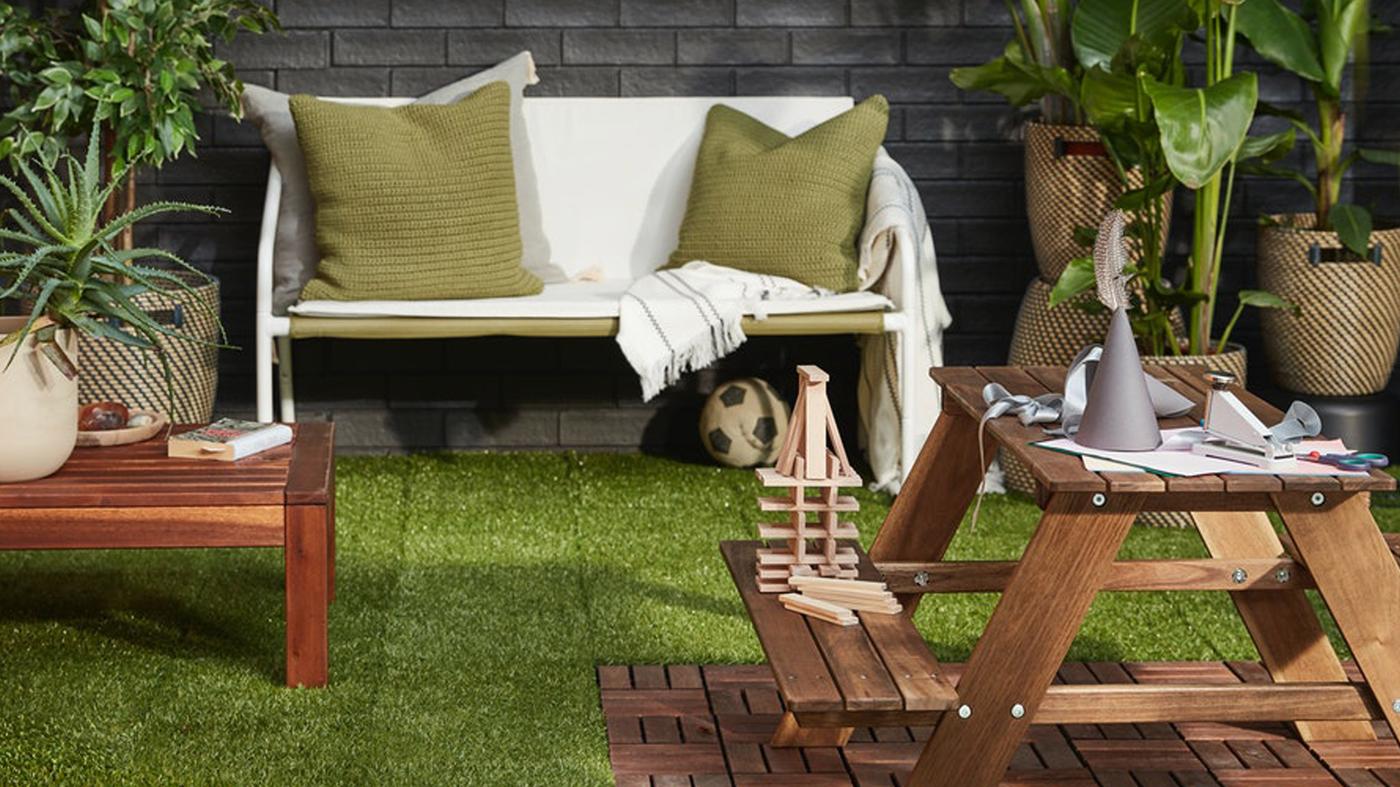 ส่วนของแผ่นพื้นที่ดูเหมือนไม้สำหรับปูนอกอาคารอยู่ใต้โซฟาสนามบุนวมสีขาว และมีหนังสือหนึ่งเล่มวางอยู่