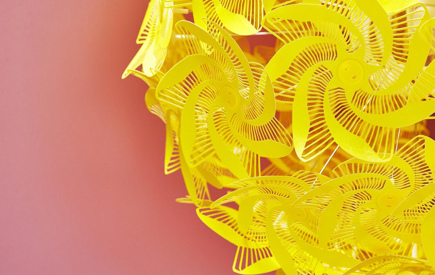 ภาพระยะใกล้ของโคมไฟที่มีรูปทรงตัดสีเหลืองบนพื้นหลังสีแดง