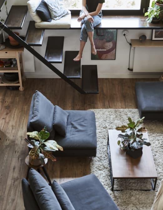 โซฟาสามชุดรอบโต๊ะกลาง และบันไดแบบเปิด