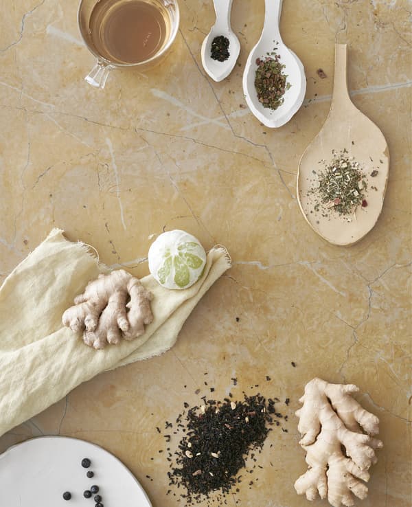 ใบชาในช้อนเซรามิค ขิง และมะนาว