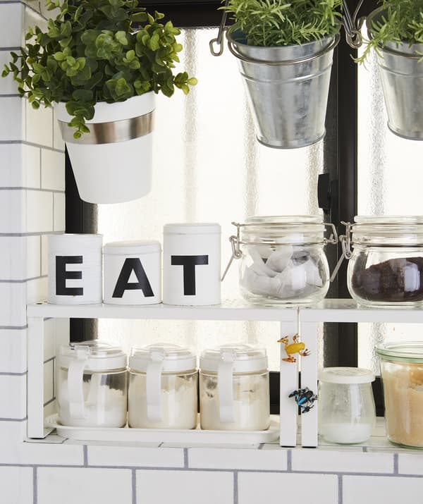 ต้นไม้และอาหารแห้งเก็บอยู่ในหม้อและโหลบนชั้นต่อเสริม