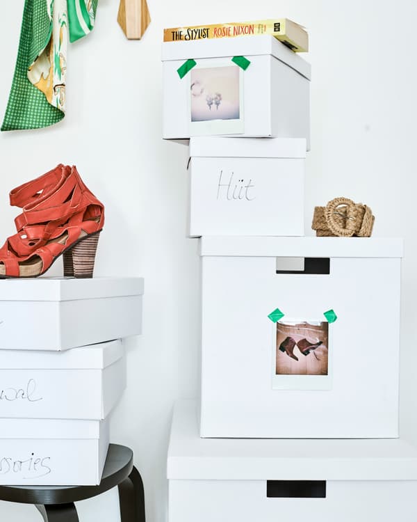 กล่องสีขาวสองกอง กองหนึ่งมีรองเท้าสีแดงวางอยู่ข้างบน แต่ละกล่องมีป้ายเขียนไว้หรือมีรูปถ่ายรองเท้าติดไว้