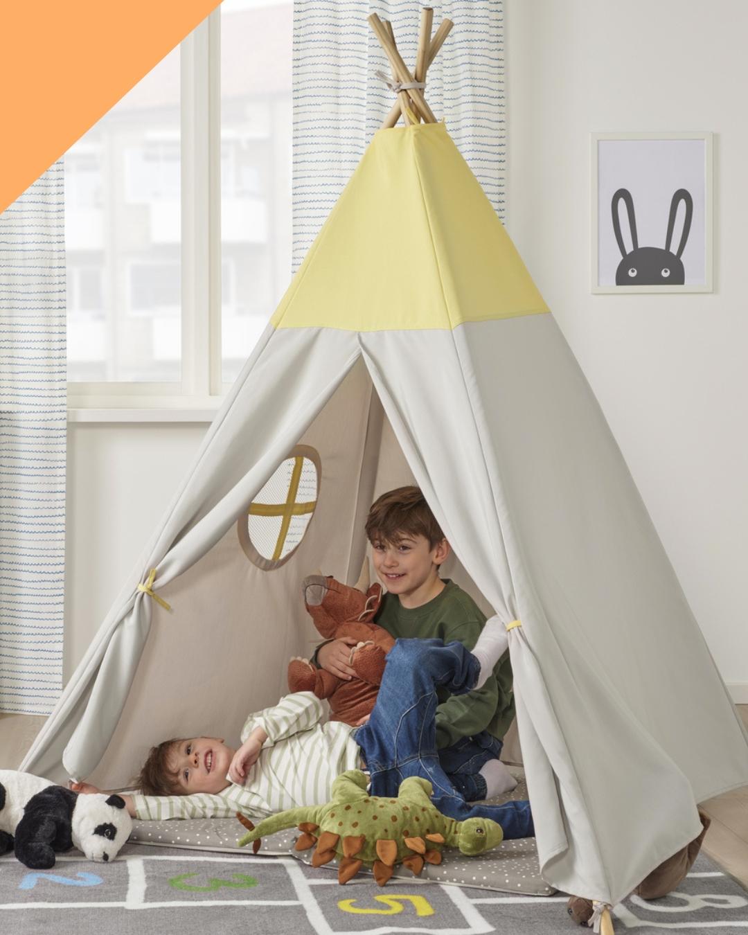 아이 둘이 텐트 안에서 웃고 있는 이미지