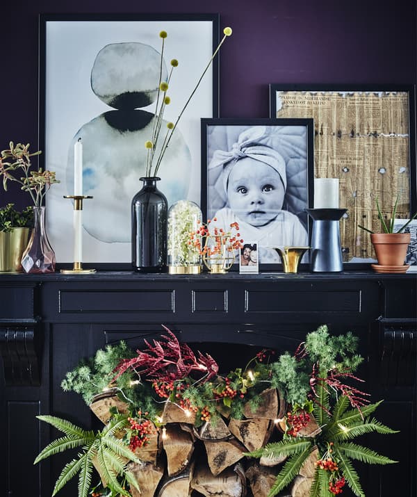 เตาผิงทาด้วยสีโทนเข้มตกแต่งด้วยเครื่องประดับงานรื่นเริงและมีของใช้เฉพาะตัววางอยู่ส่วนบน