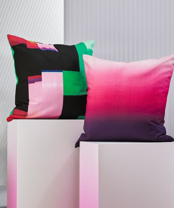 หมอนอิงสีสันสดใสสองใบวางอยู่บนแท่นวางสีขาว