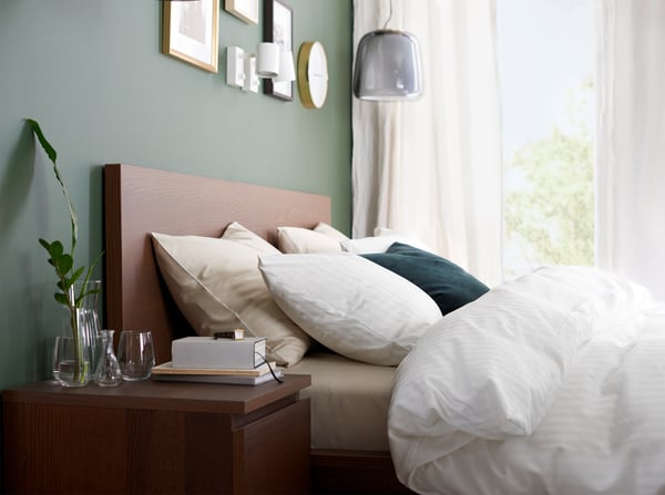 브라운스테인 물푸레무늬목으로 만든 침대프레임과 침대협탁, 화이트 색상의 이불커버, 베개커버와 커튼