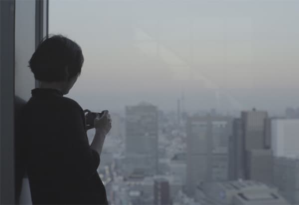 ผู้หญิงถ่ายรูปเมืองจากหน้าต่าง