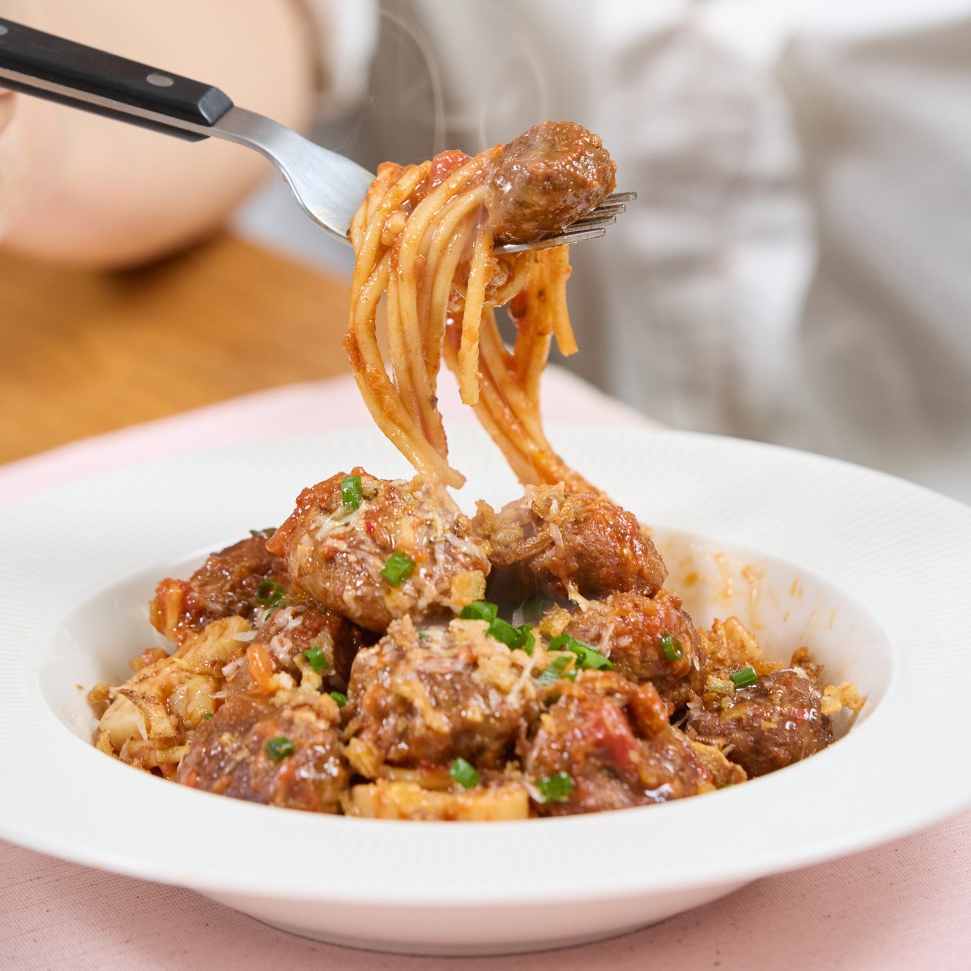 완성된 파스타와 미트볼을 들어올리는 포크의 모습