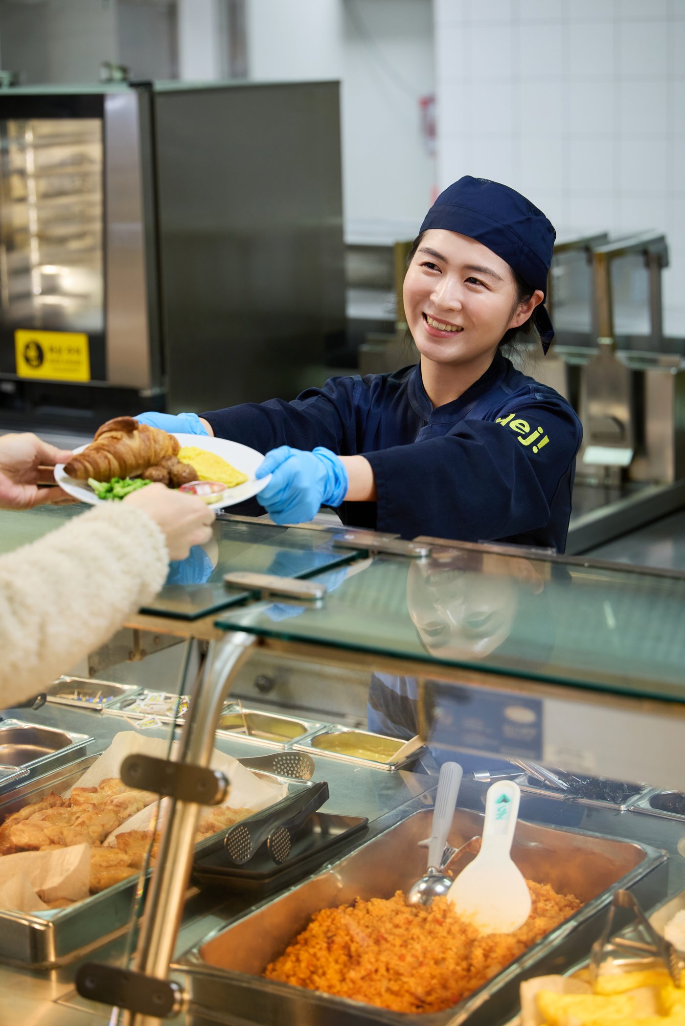 웃으면서 메뉴가 담긴 그릇을 내어주는 직원의 모습