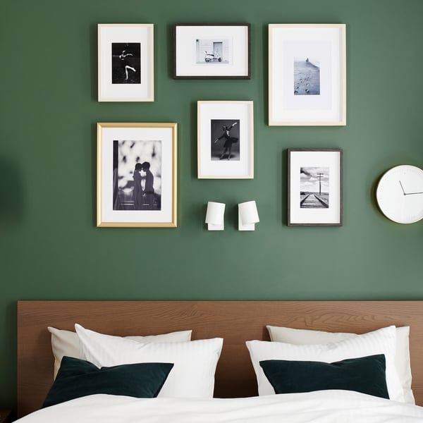 브라운스테인 물푸레무늬목으로 만든 침대프레임, 화이트 색상의 이불커버와 베개커버, 골드 테두리의 액자