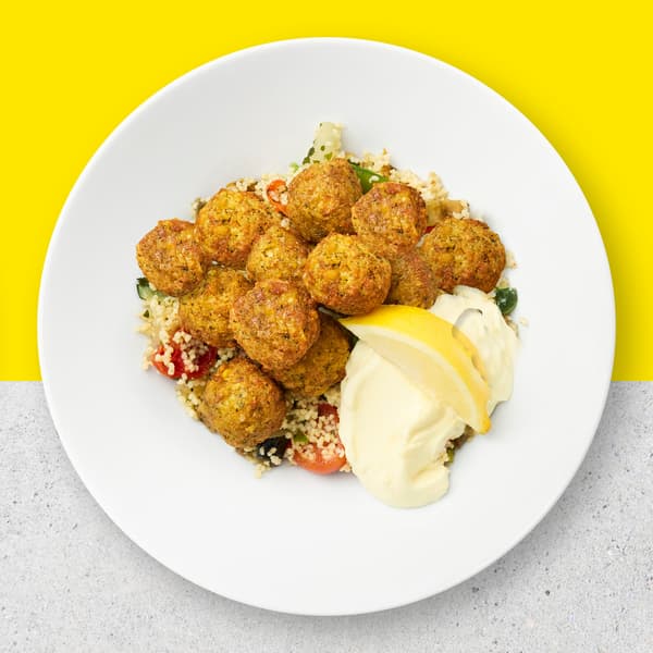 12 Falafel balls with couscous and vegetables with aioli sauce and lemon.