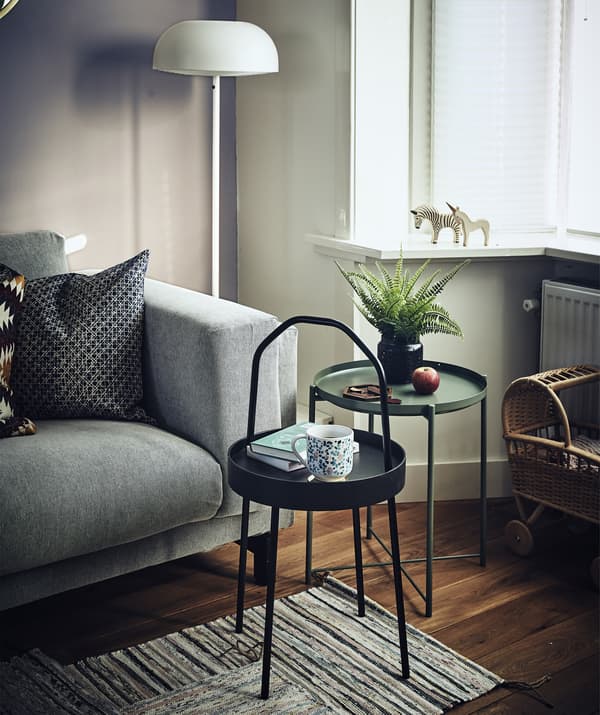 โต๊ะข้างทรงกลมขนาดเล็ก 2 ตัวอยู่ข้างโซฟาในห้องนั่งเล่น