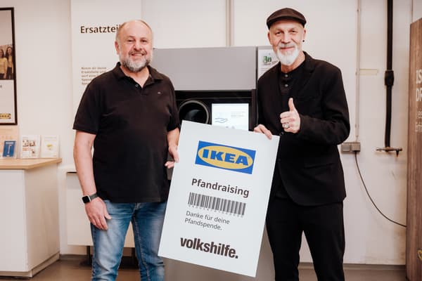 2 Männer halten einen großen Kassabon mit dem Text: 