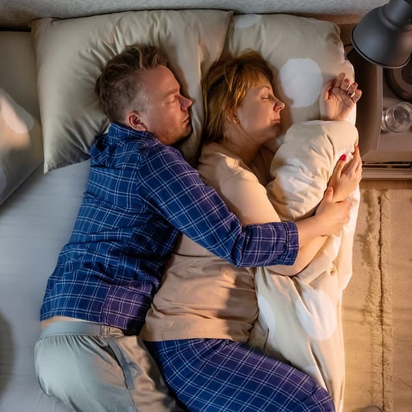 2 people sleeping in bed, spooning