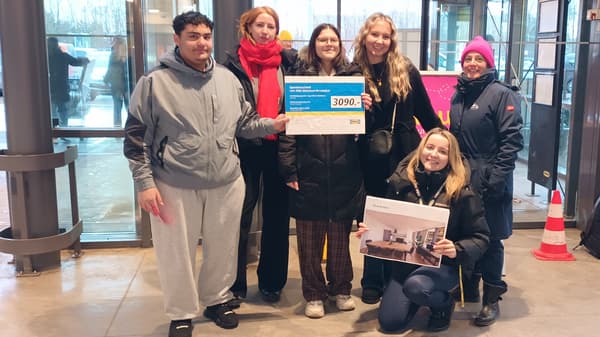 2 Personen stehen im weihnachtlich dekorierten IKEA Einrichtungshaus hinter einem Einkaufwagen randvoll mit Geschirr, Besteck, Töpfen und weiteren Kochuntensilien. Eine davon trägt ein blaues IKEA Mitarbeitenden T-Shirt.  